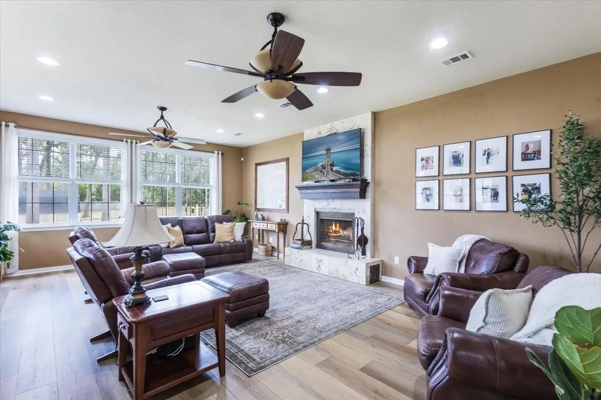 Living room featuring recessed lighting, visible vents, light wood-style floors, a stone fireplace, and baseboards