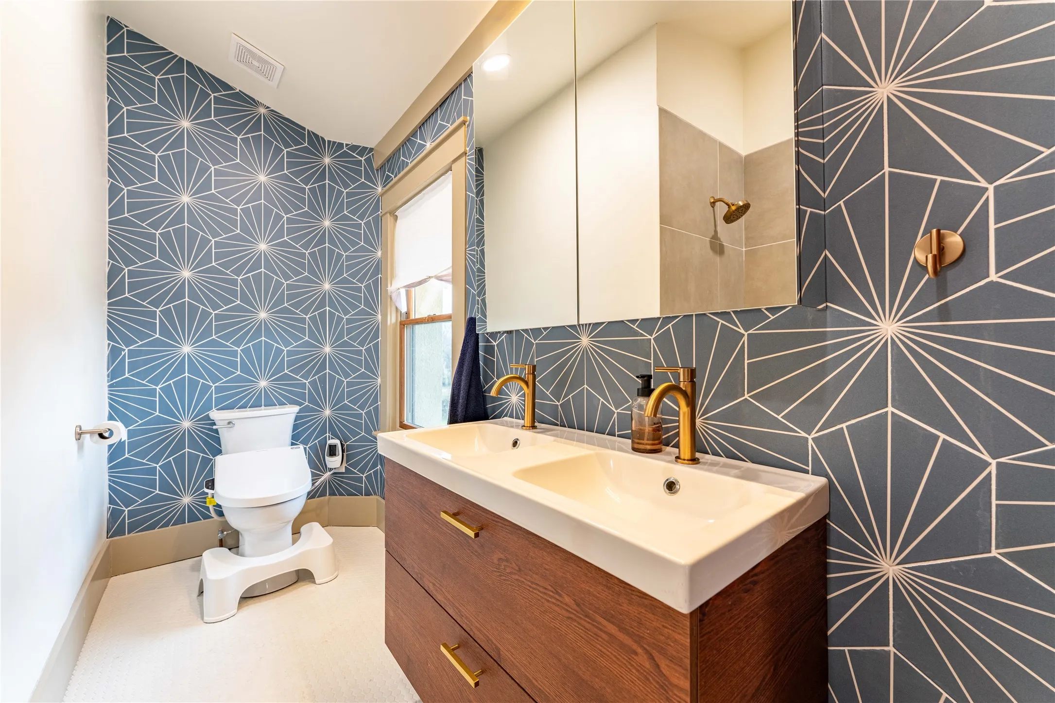 Bathroom featuring visible vents, wallpapered walls, baseboards, toilet, and vanity