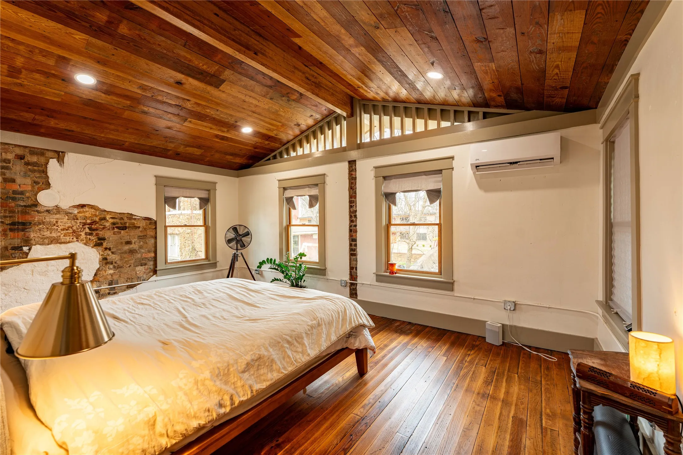 Bedroom featuring a wall unit AC, wood-type flooring, wood ceiling, and lofted ceiling