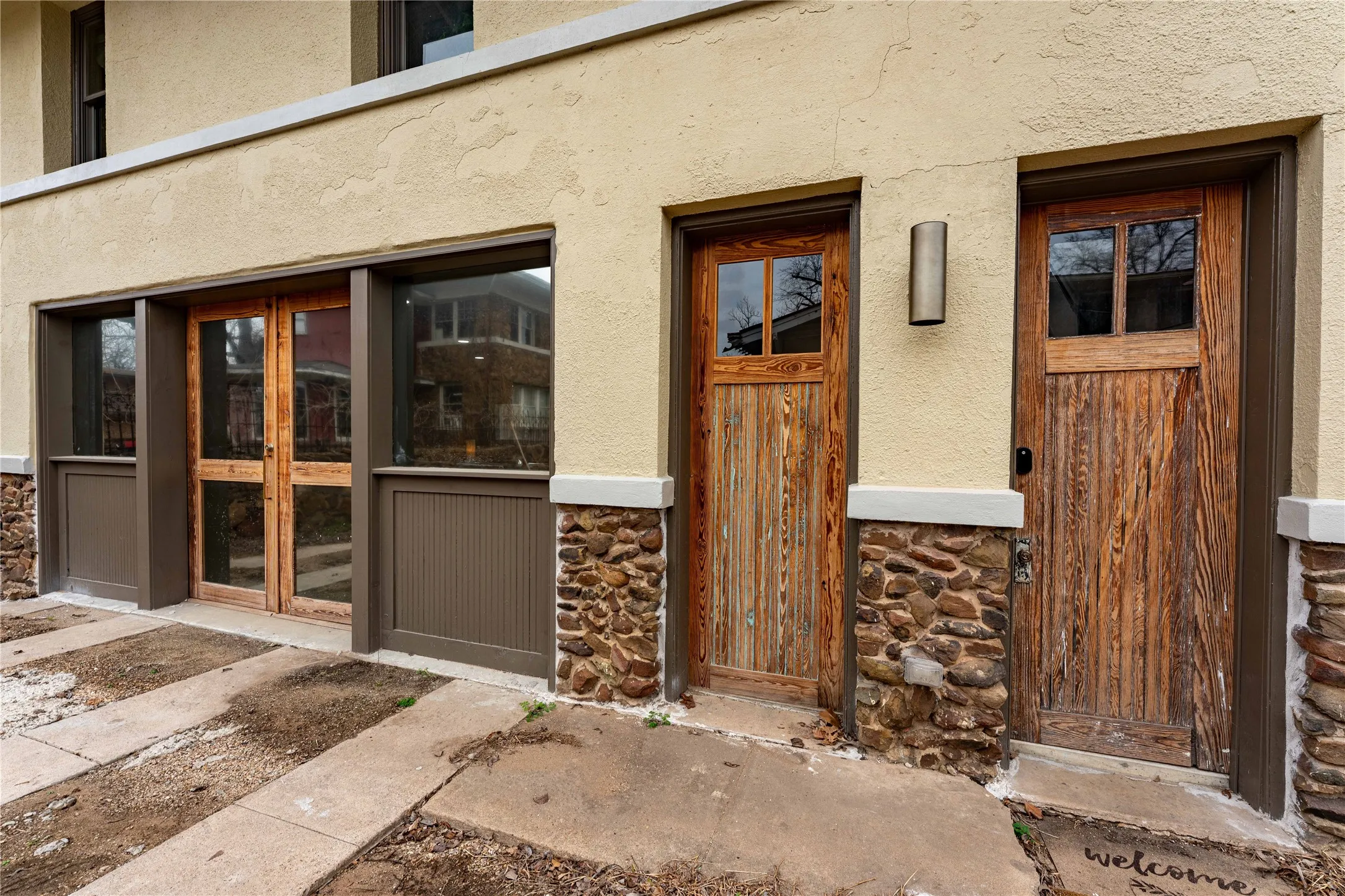 View of exterior entry with stone siding and stucco siding