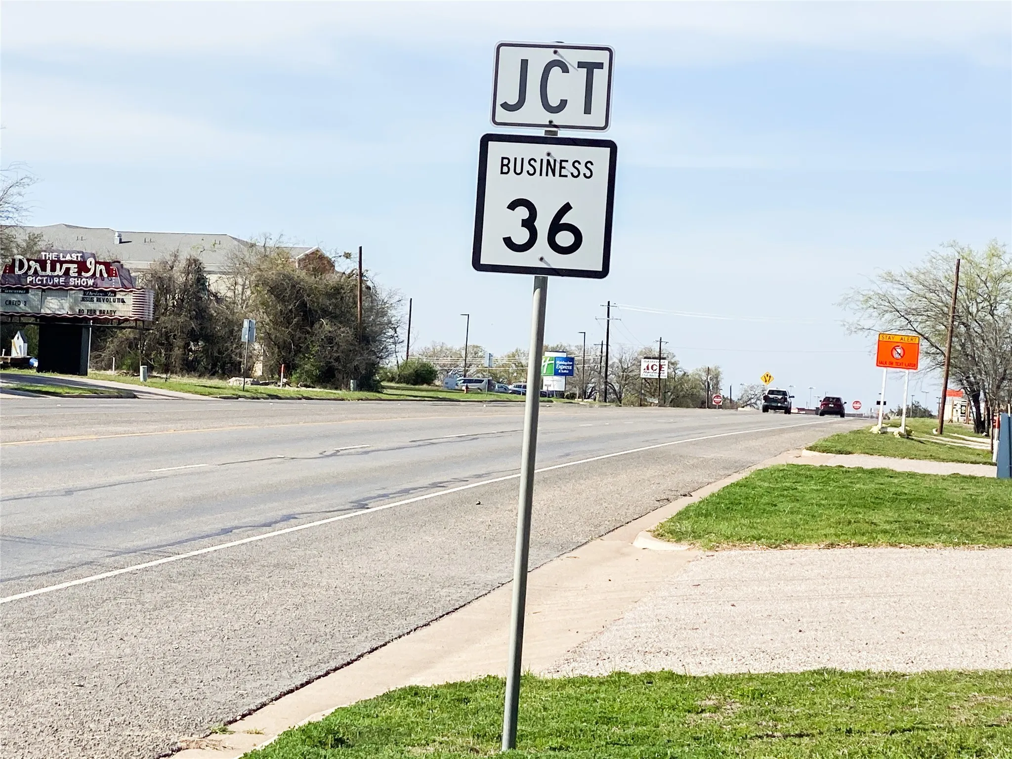 View of asphalt road featuring traffic signs