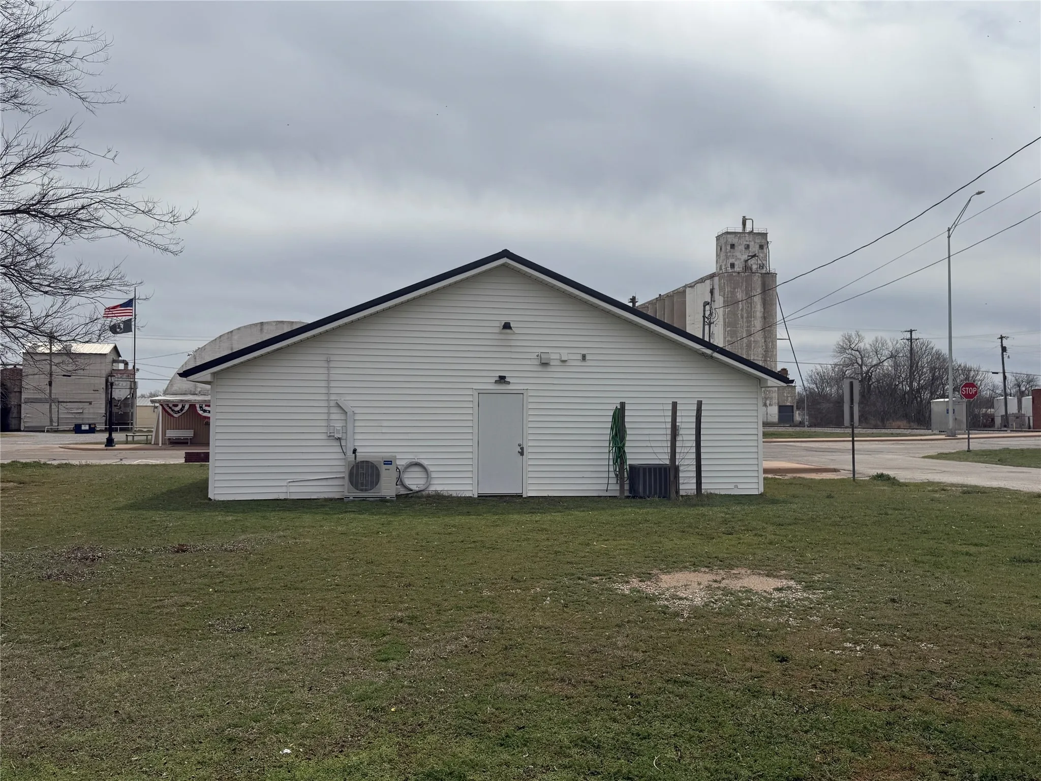 Back of house with a lawn and ac unit