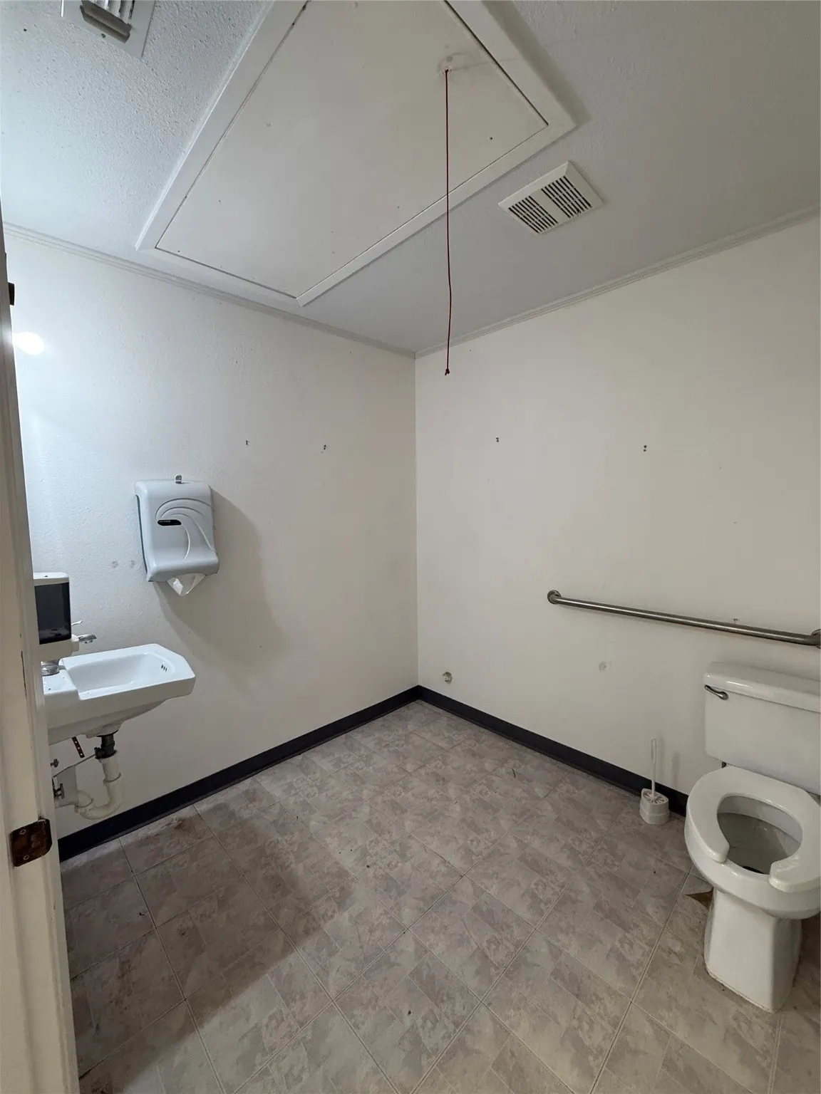Half bathroom featuring a sink, visible vents, baseboards, and toilet