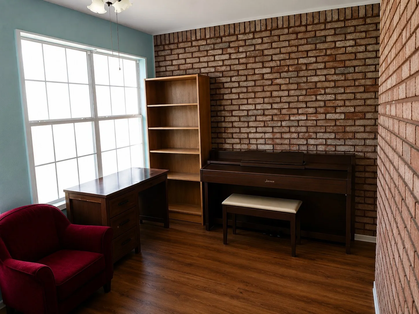 Office space featuring wood finished floors and brick wall