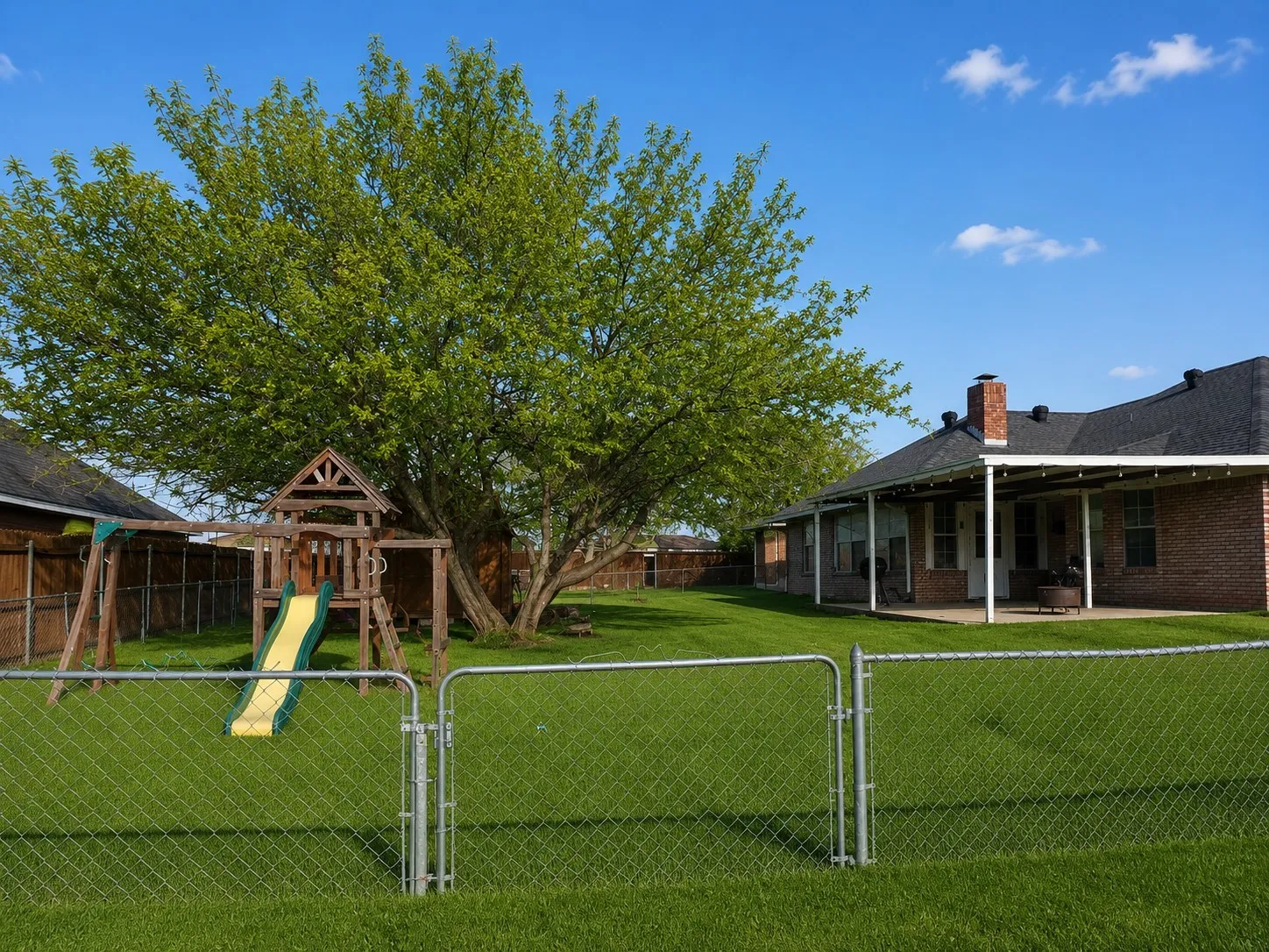 View of yard with a playground, a gate, and a fenced backyard