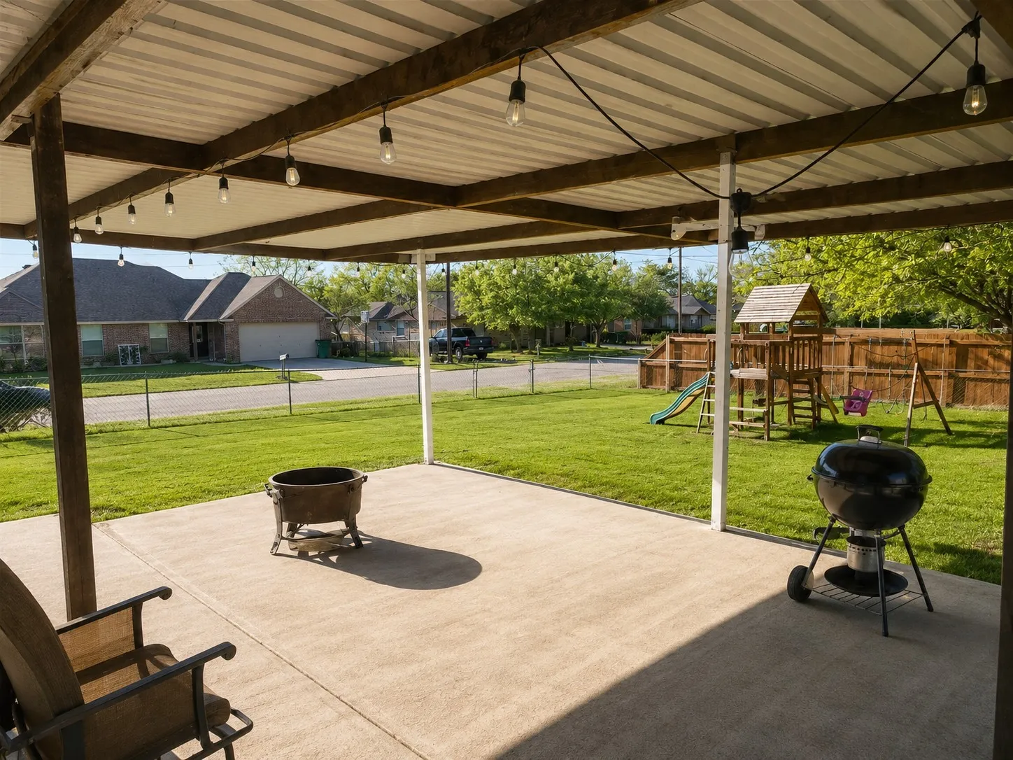 View of patio featuring fence and a playground