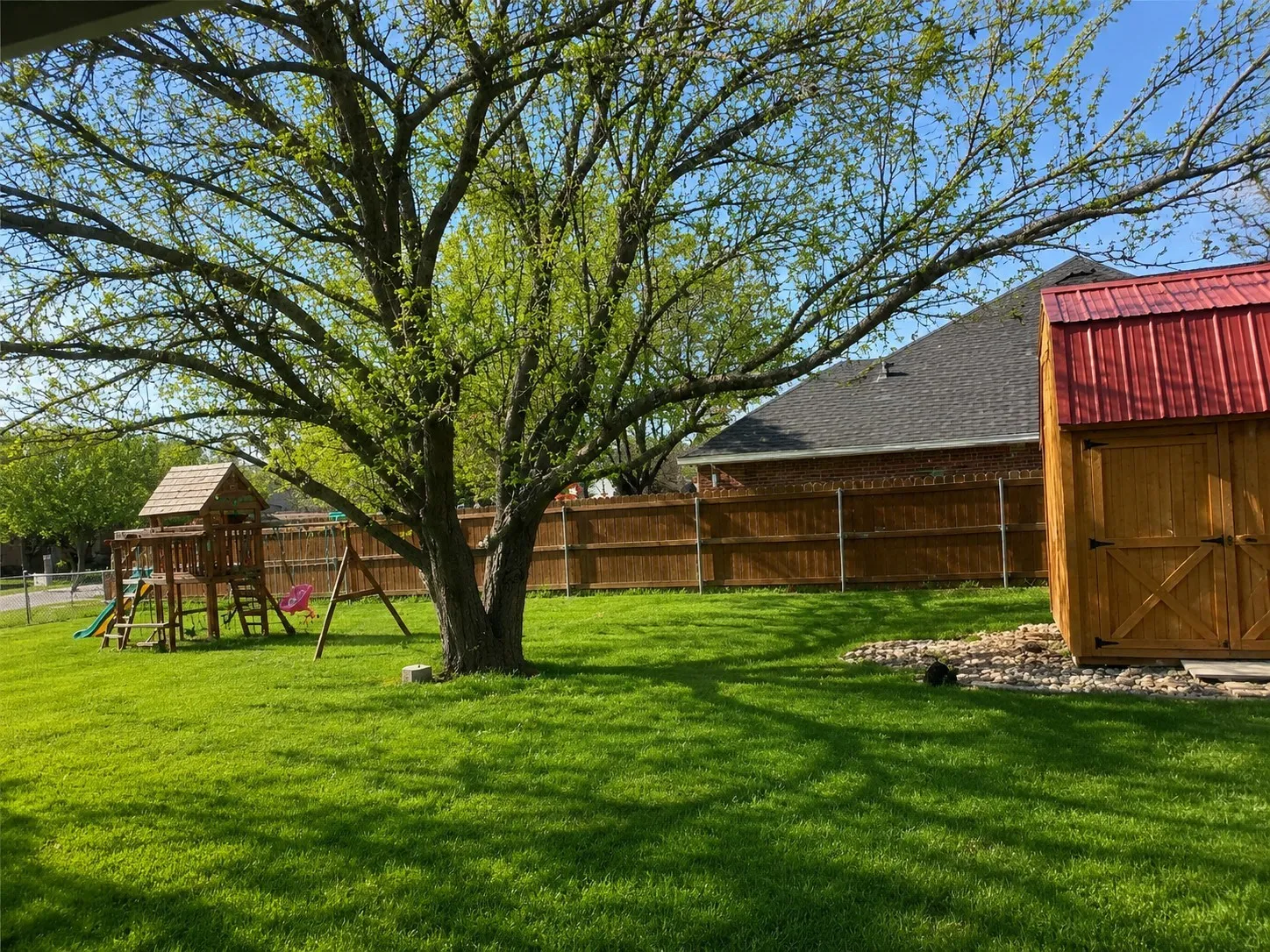 iew of property exterior featuring a yard and fence