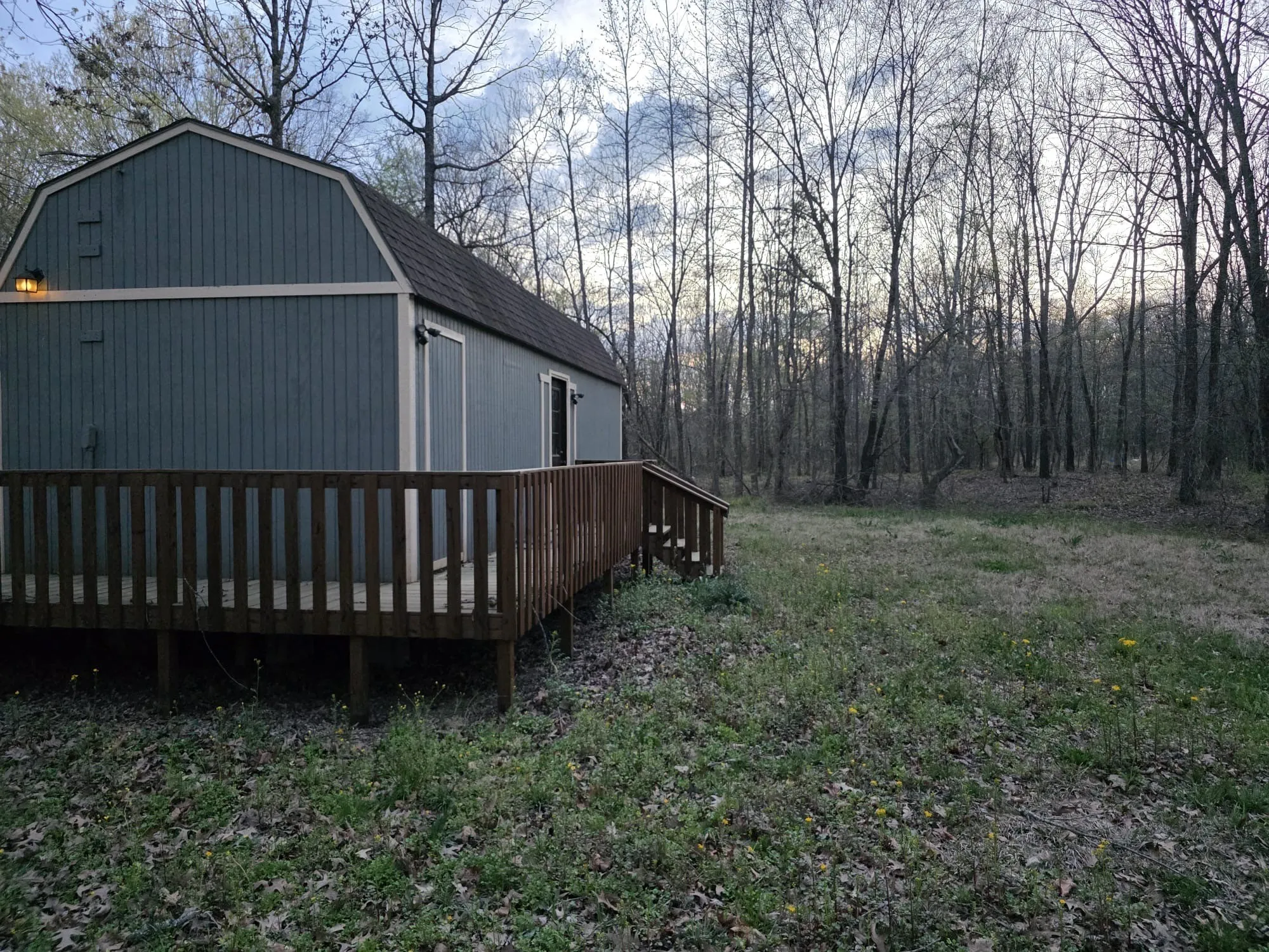 View of home's exterior featuring a gambrel roof and a deck