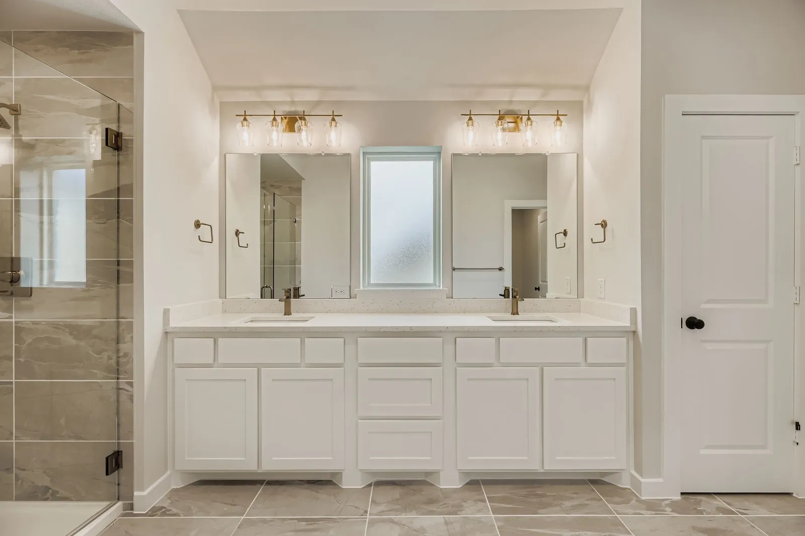 Full bathroom featuring a shower stall, double vanity, and marble look tiles