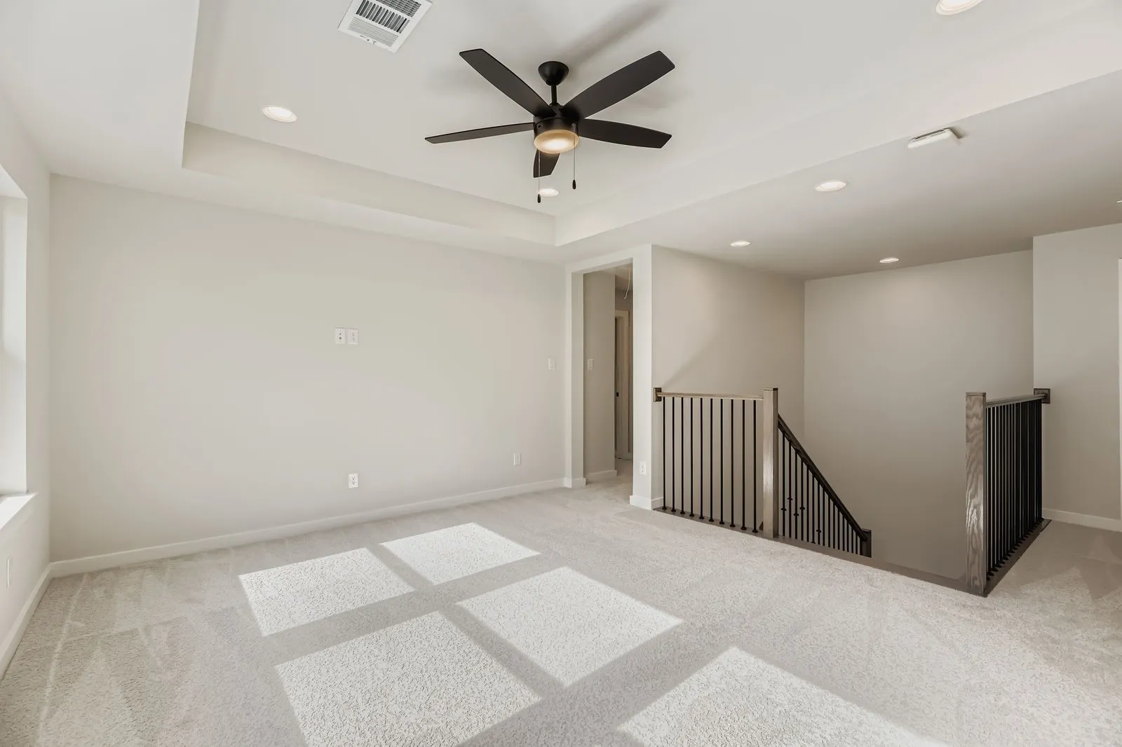 Carpeted spare room featuring recessed lighting, a tray ceiling, and ceiling fan