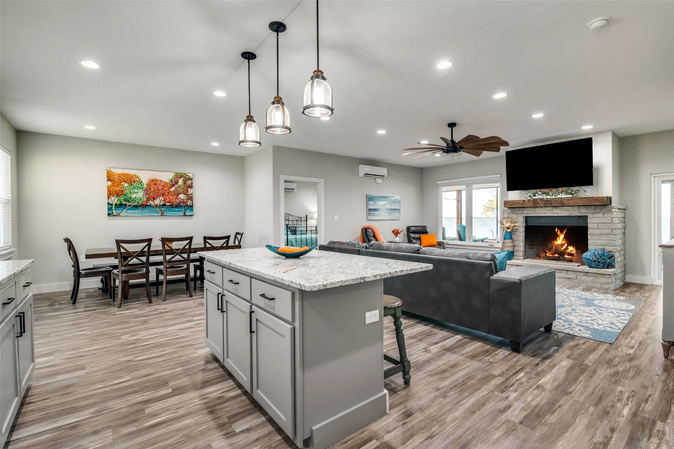 Kitchen featuring a lit fireplace, kitchen island, lighting and dining area