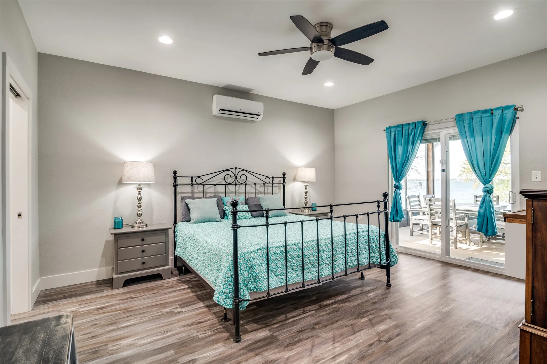 Bedroom with lake view, doors to back porch , recessed lighting and ceiling fan
