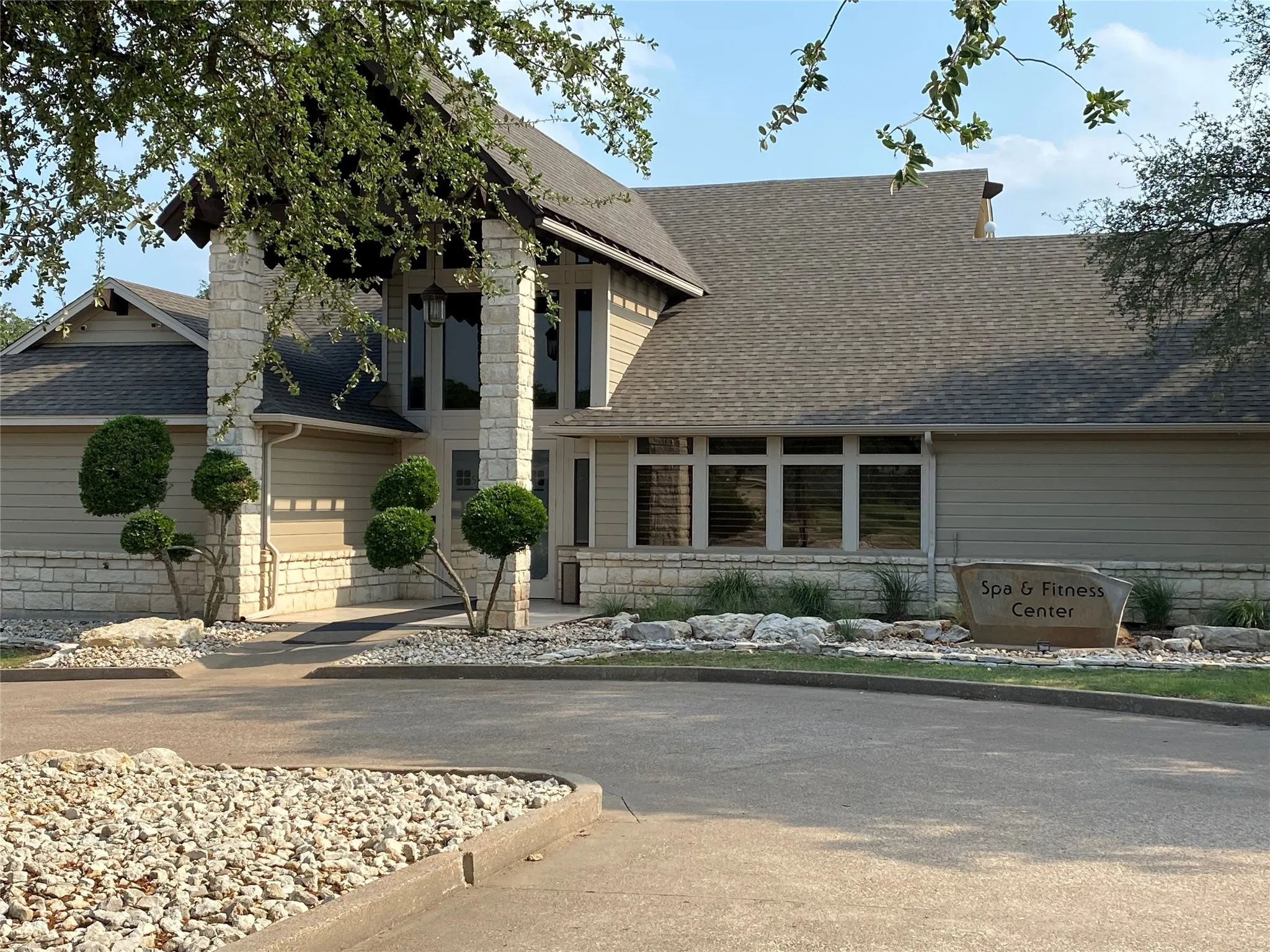 View of front of property with stone siding and a shingled roof