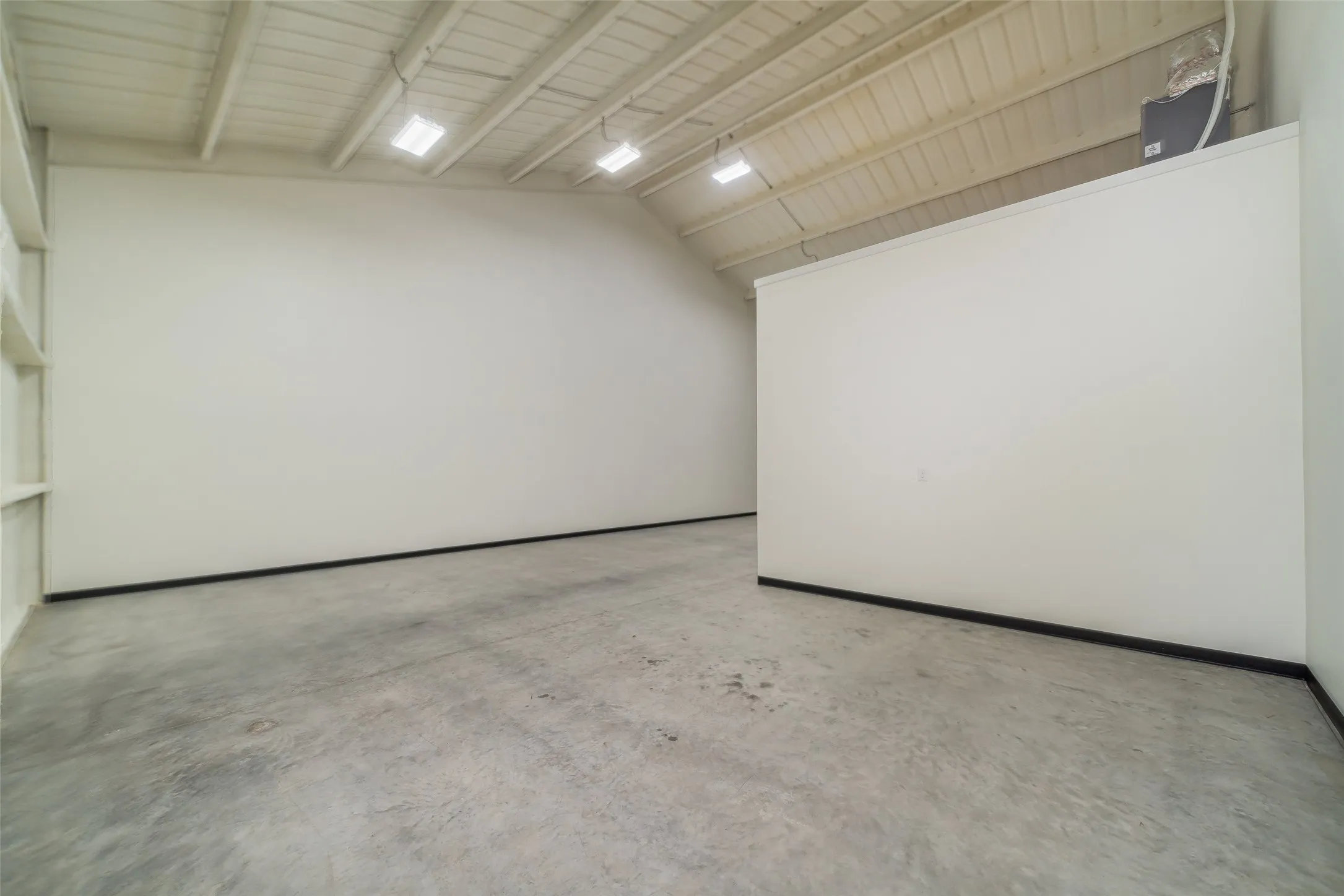 Empty room with concrete flooring and baseboards