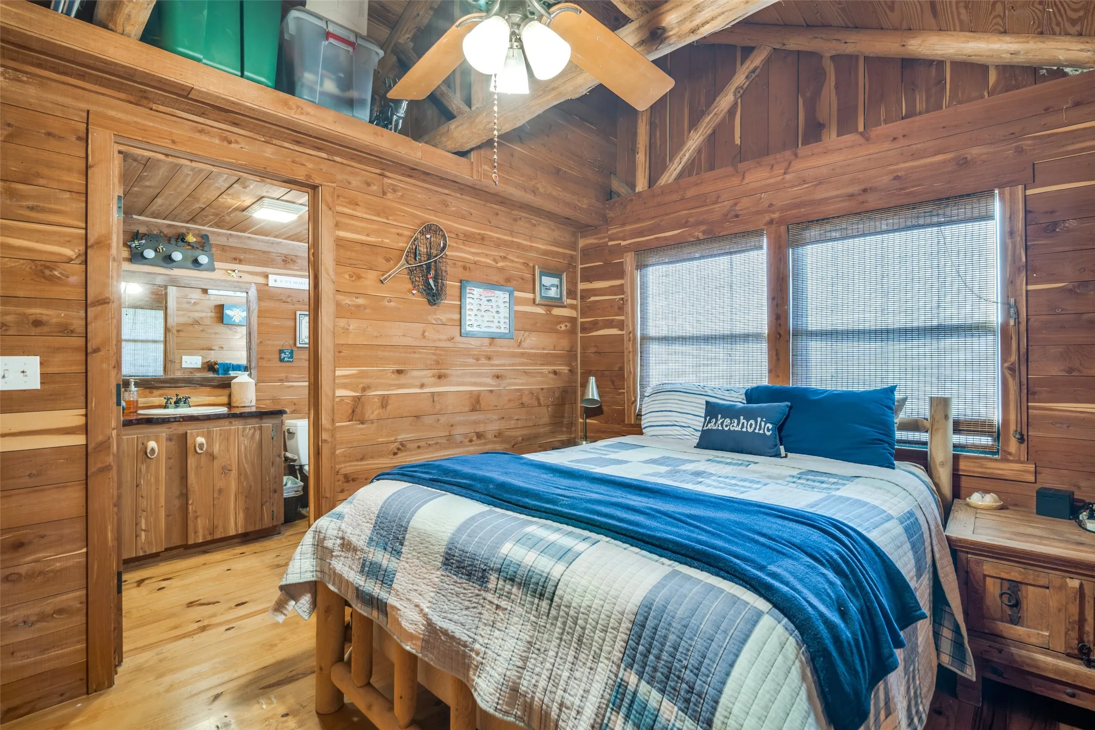 Bedroom featuring wood walls, light wood-floors, and lofted ceiling with beams