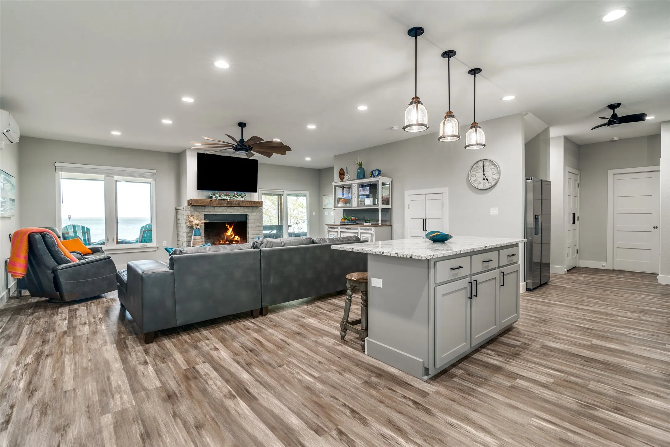 Kitchen featuring stainless steel fridge with ice dispenser, ceiling fan, gray cabinetry, and light wood-style floors