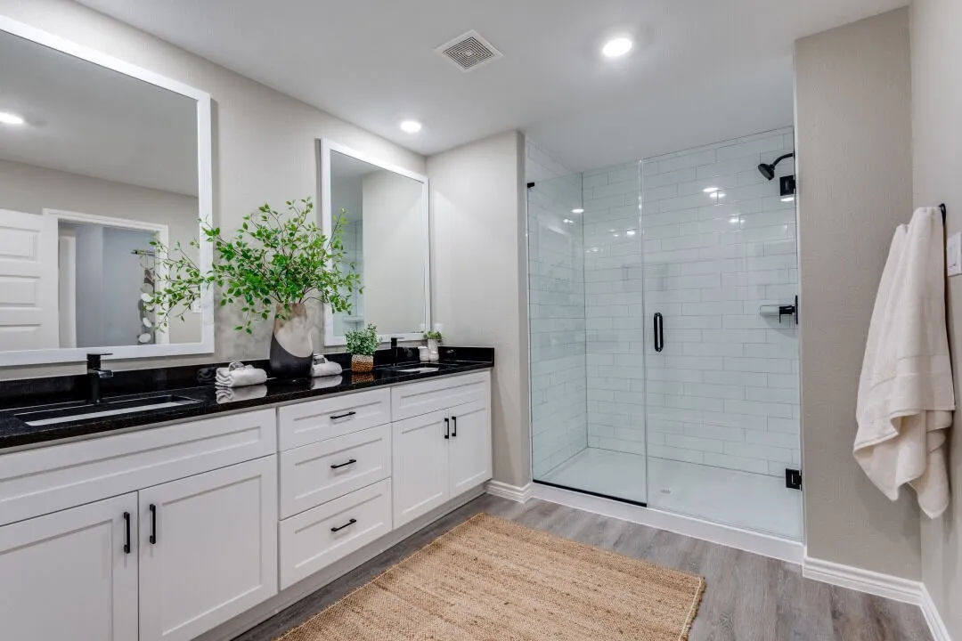 Full bathroom with a stall shower, a sink, wood finished floors, visible vents, and double vanity