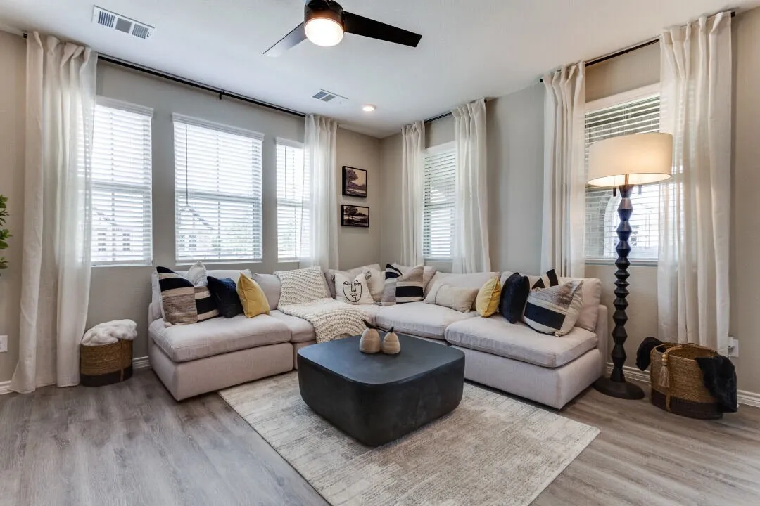Living area featuring baseboards, ceiling fan, visible vents, and light wood-style floors