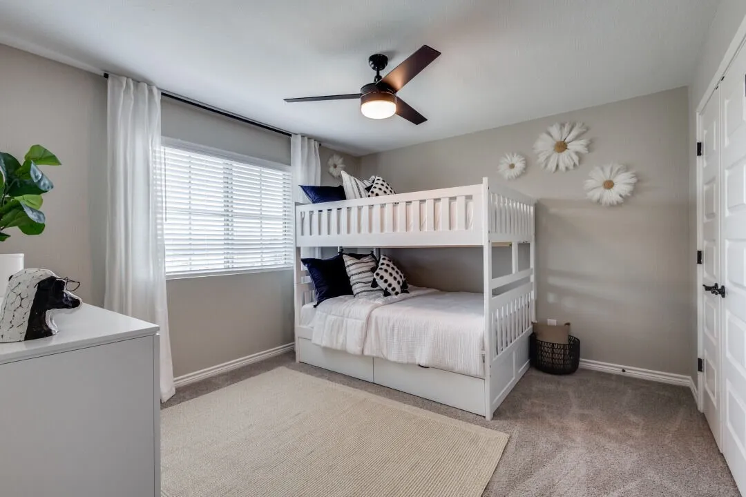 Carpeted bedroom featuring baseboards and a ceiling fan