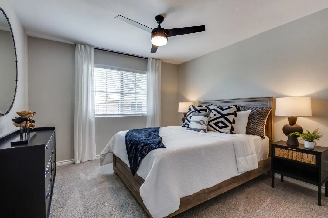 Bedroom featuring light carpet, baseboards, and ceiling fan