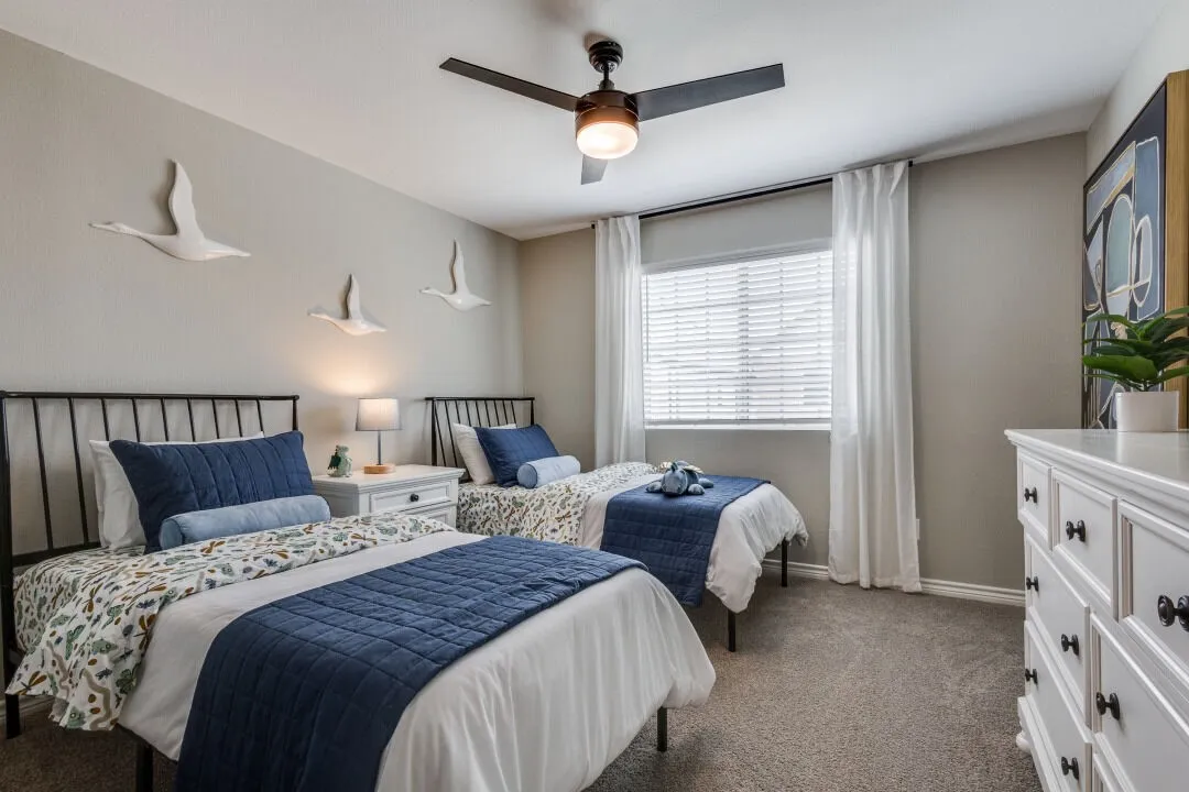 Carpeted bedroom with baseboards and a ceiling fan