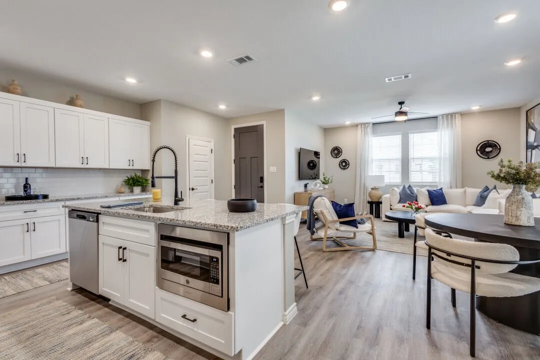 Kitchen with a sink, open floor plan, stainless steel appliances, a kitchen island with sink, and visible vents