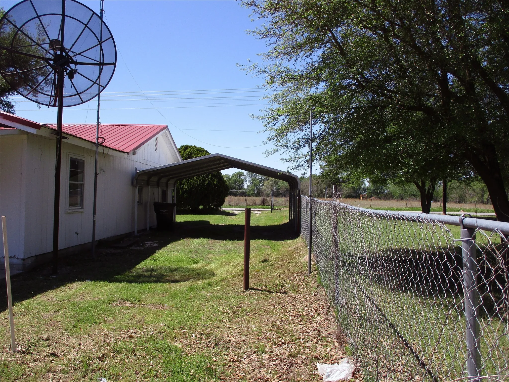 View of yard featuring a detached carport and fence