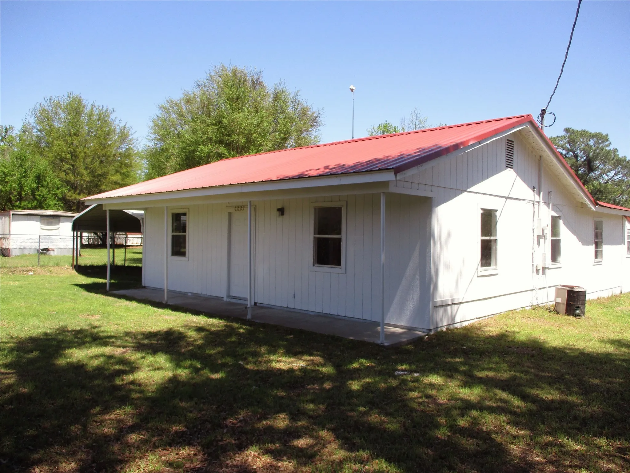 Back of property with metal roof and a lawn