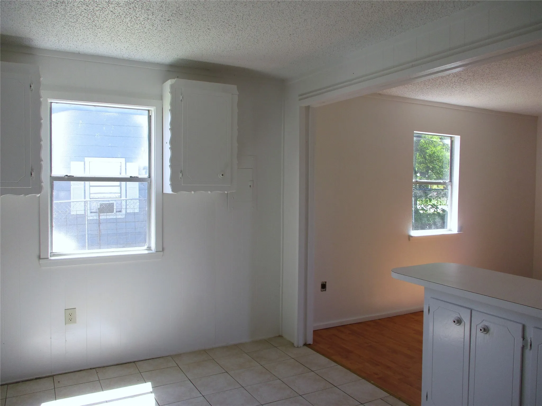 Empty room featuring light tile patterned flooring, electric panel, and a textured ceiling