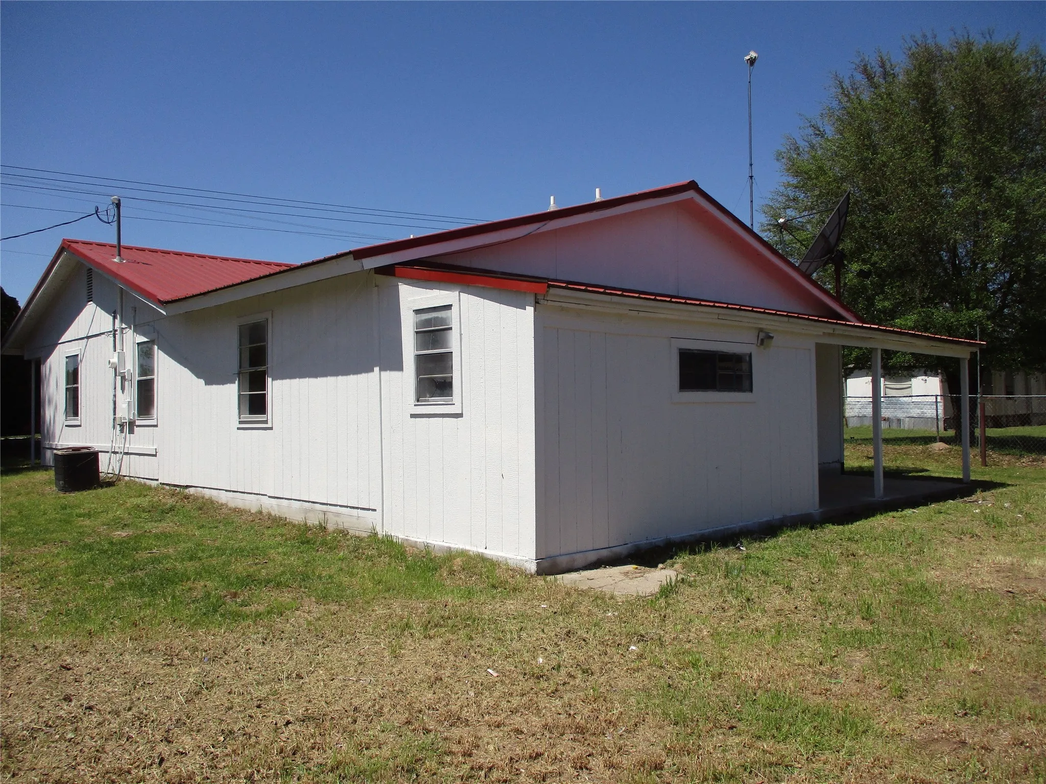 View of side of home featuring a yard and metal roof