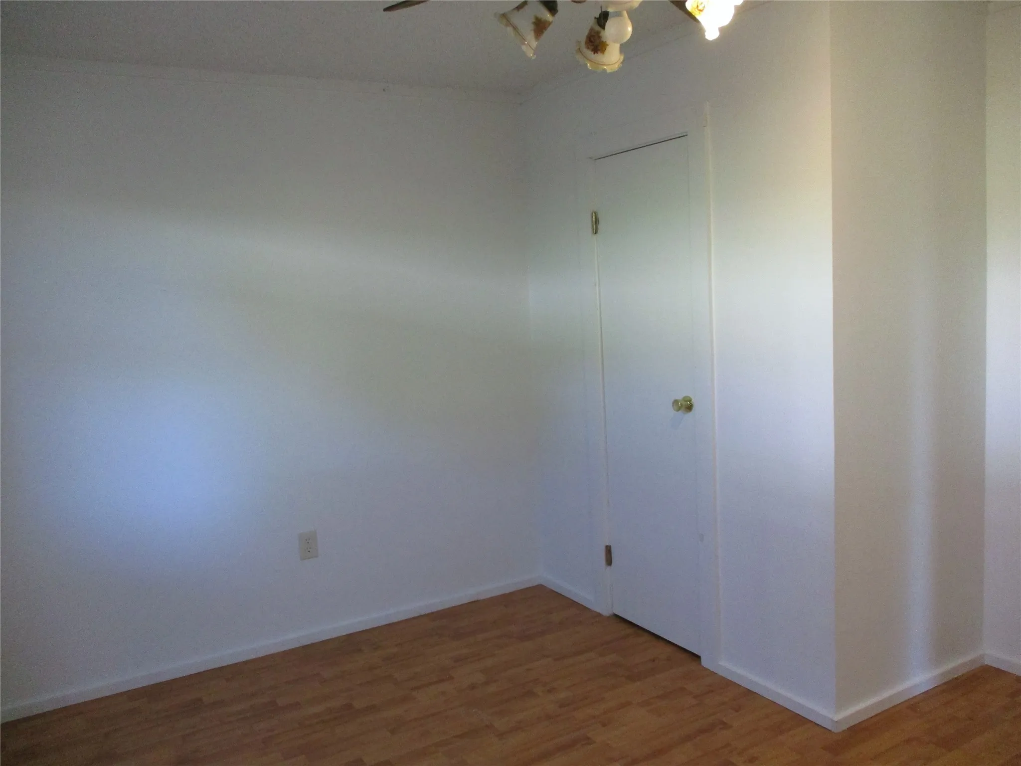 Spare room with light wood-style floors, baseboards, and an inviting chandelier