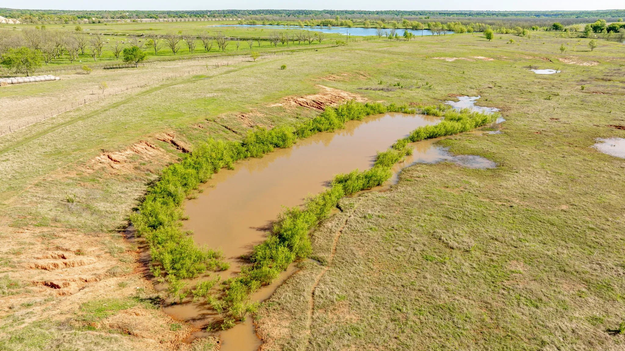 Birds eye view of property featuring a water view and a rural view