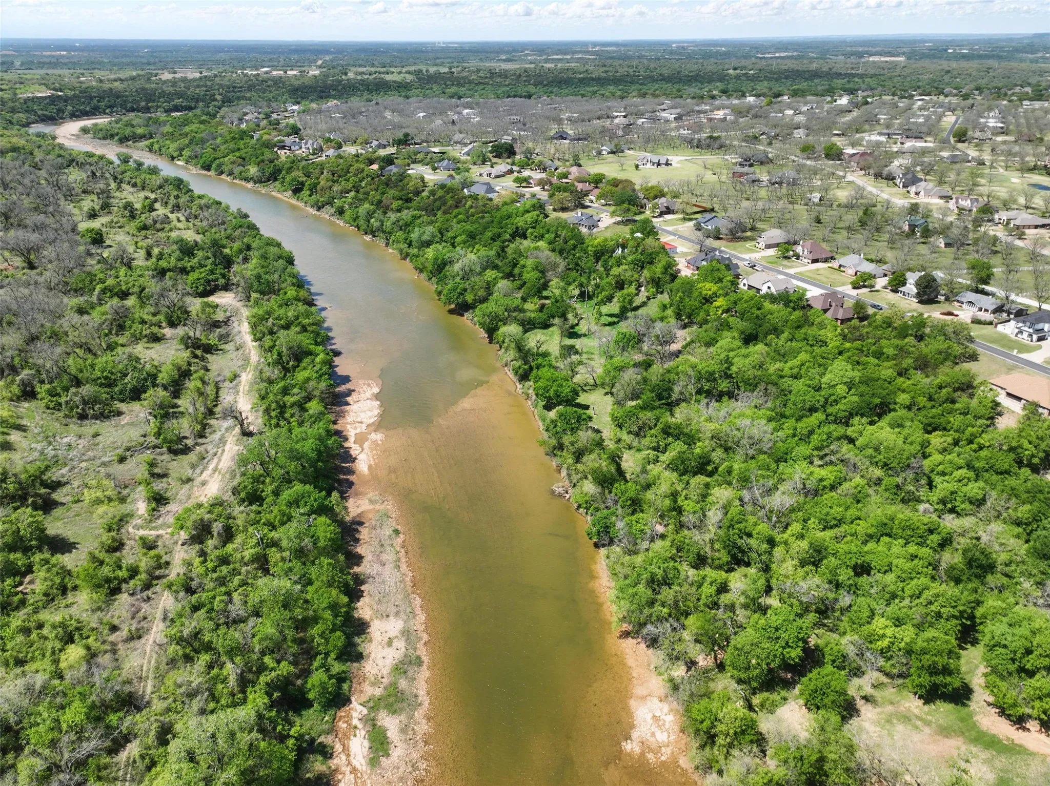 Brazos River frontage with mature tree coverage and natural elevation.
