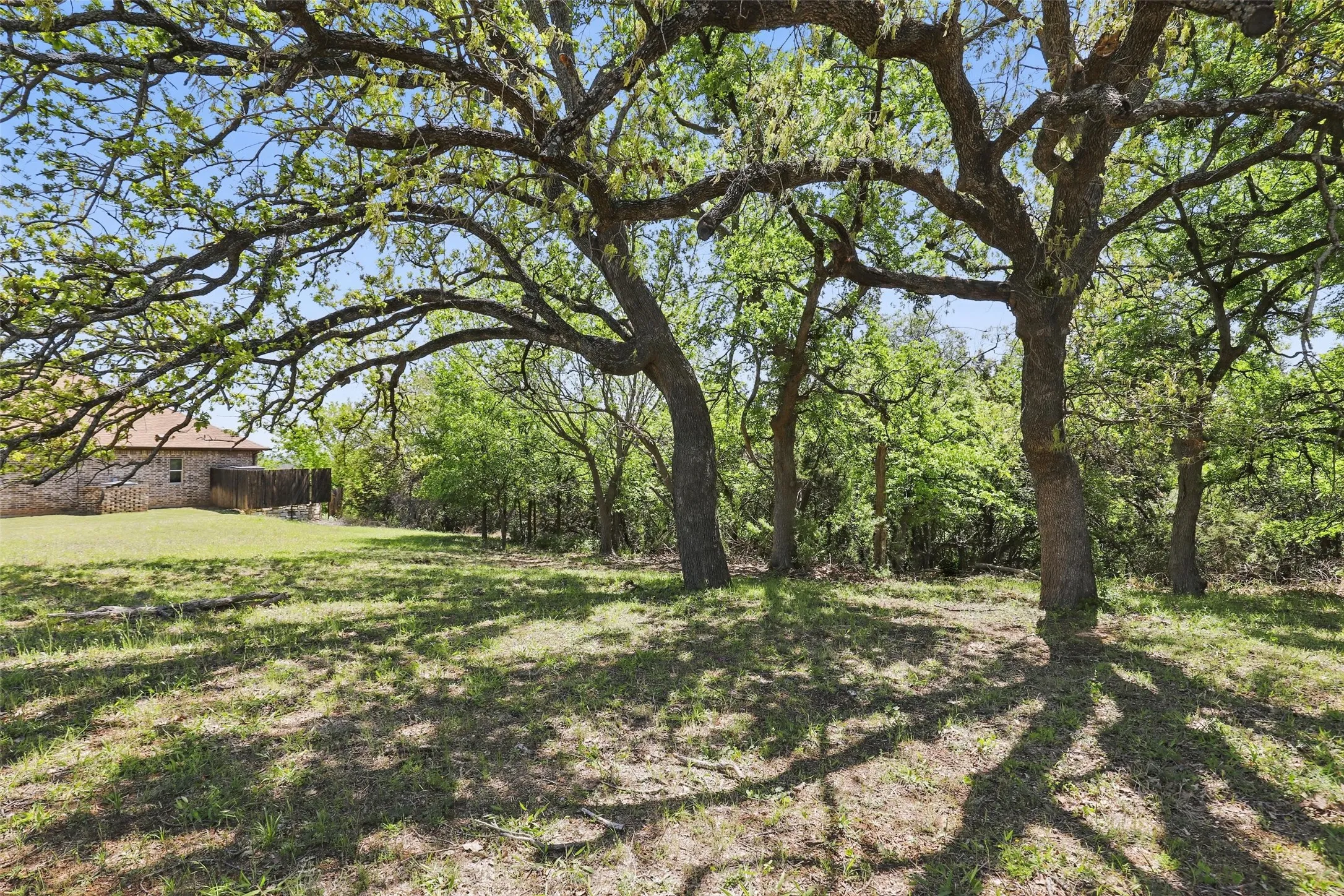 Mature trees provide privacy and natural shade at the front of the property.