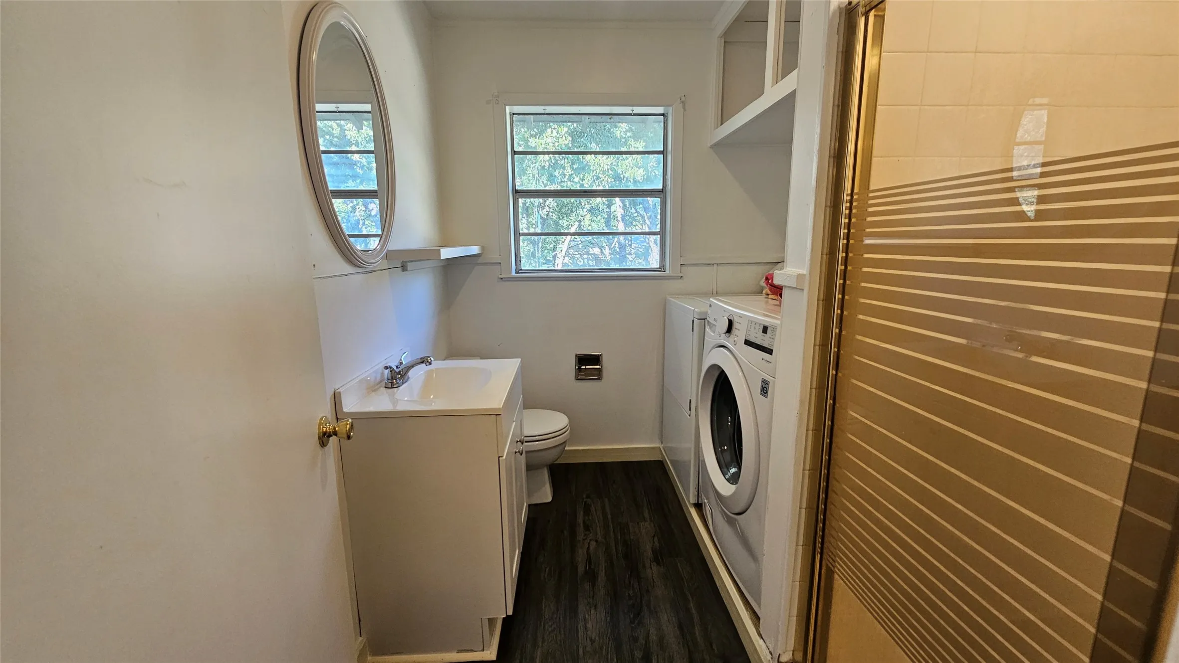 Laundry room with independent washer and dryer, dark wood-style floors, and crown molding