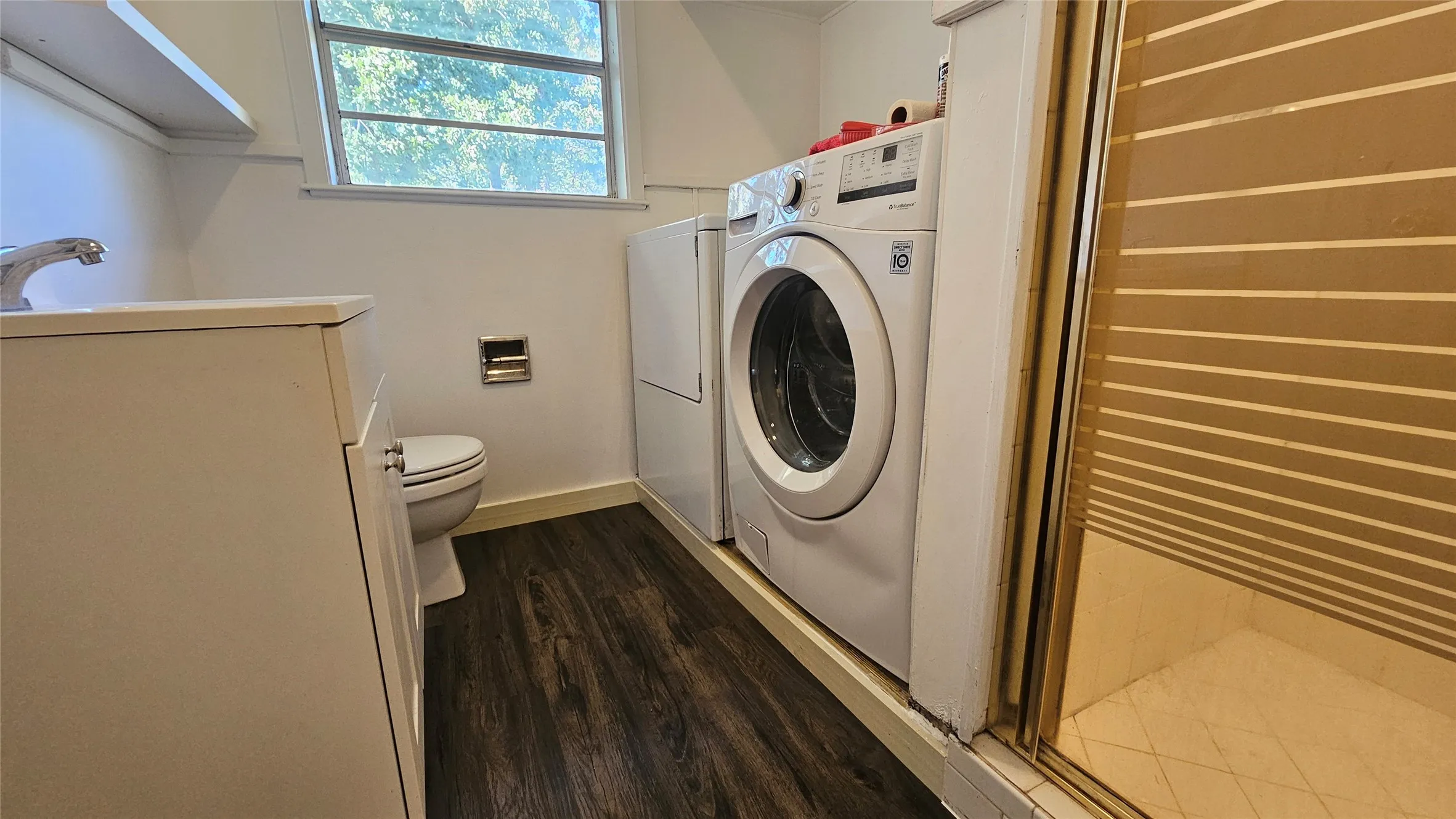 Bathroom featuring separate washer and dryer, dark wood-type flooring, vanity, and a stall shower