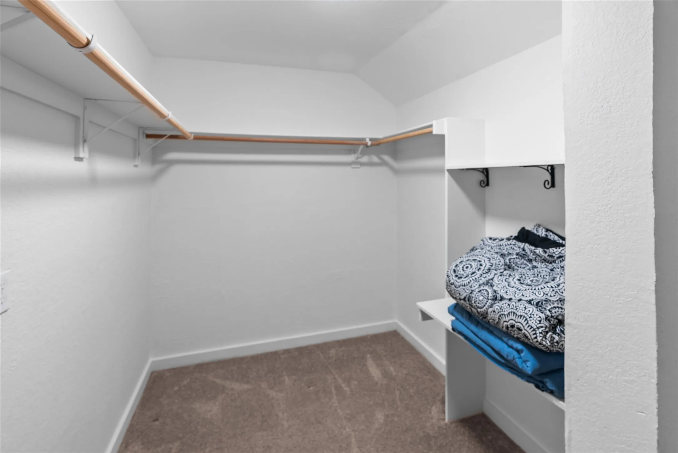 Walk in closet featuring carpet and lofted ceiling