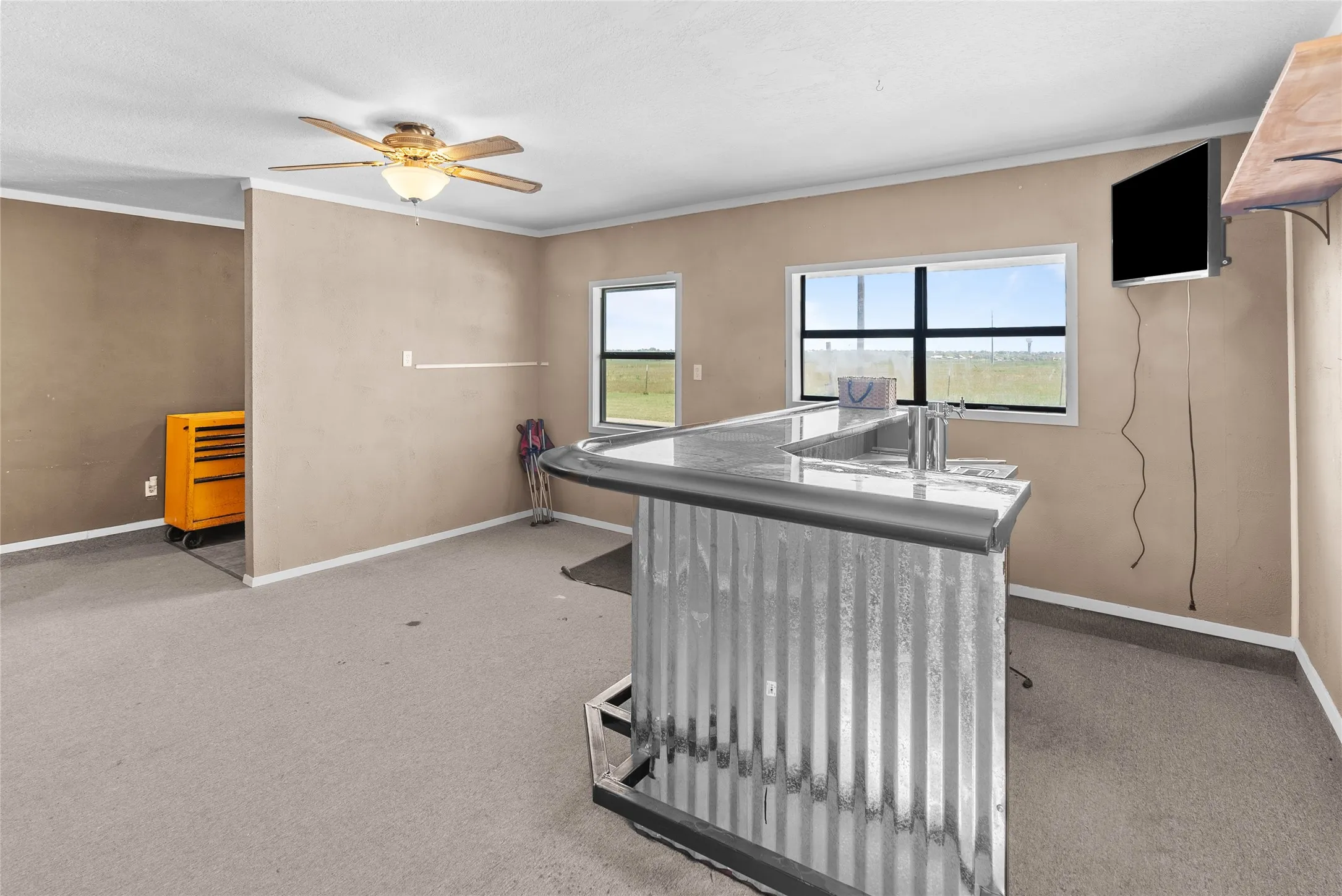 Home office with crown molding, ceiling fan, baseboards, and carpet floors