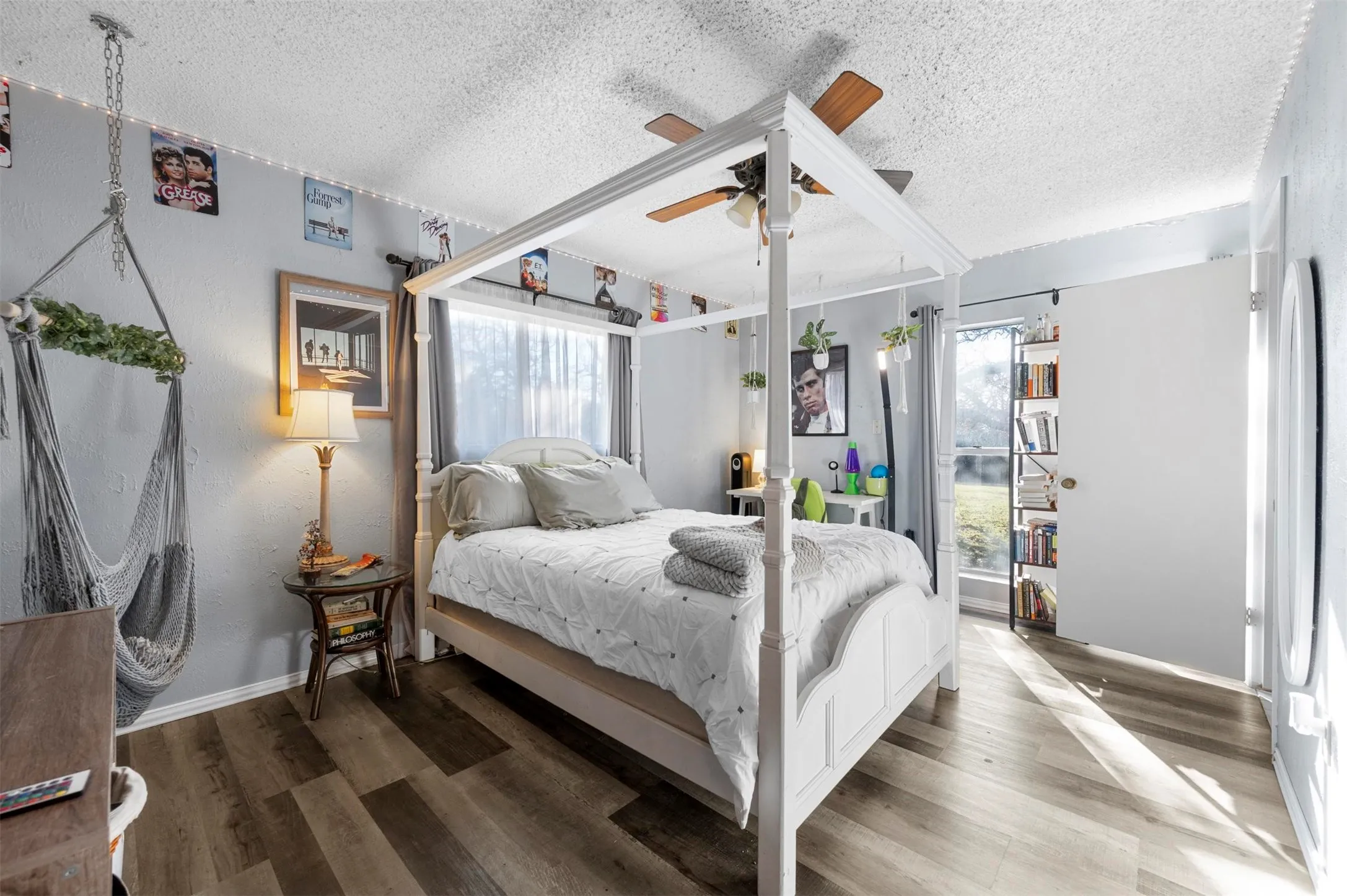 Bedroom with a textured ceiling, wood finished floors, and ceiling fan