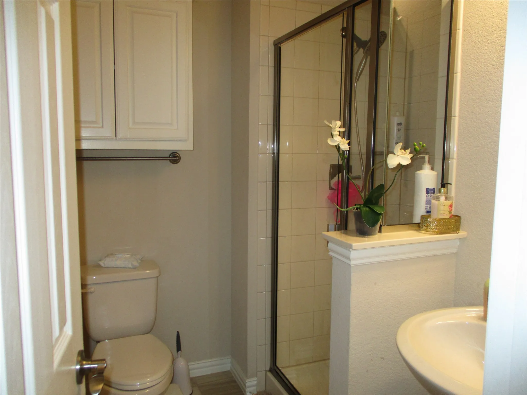 Bathroom with a shower stall, a sink, and toilet