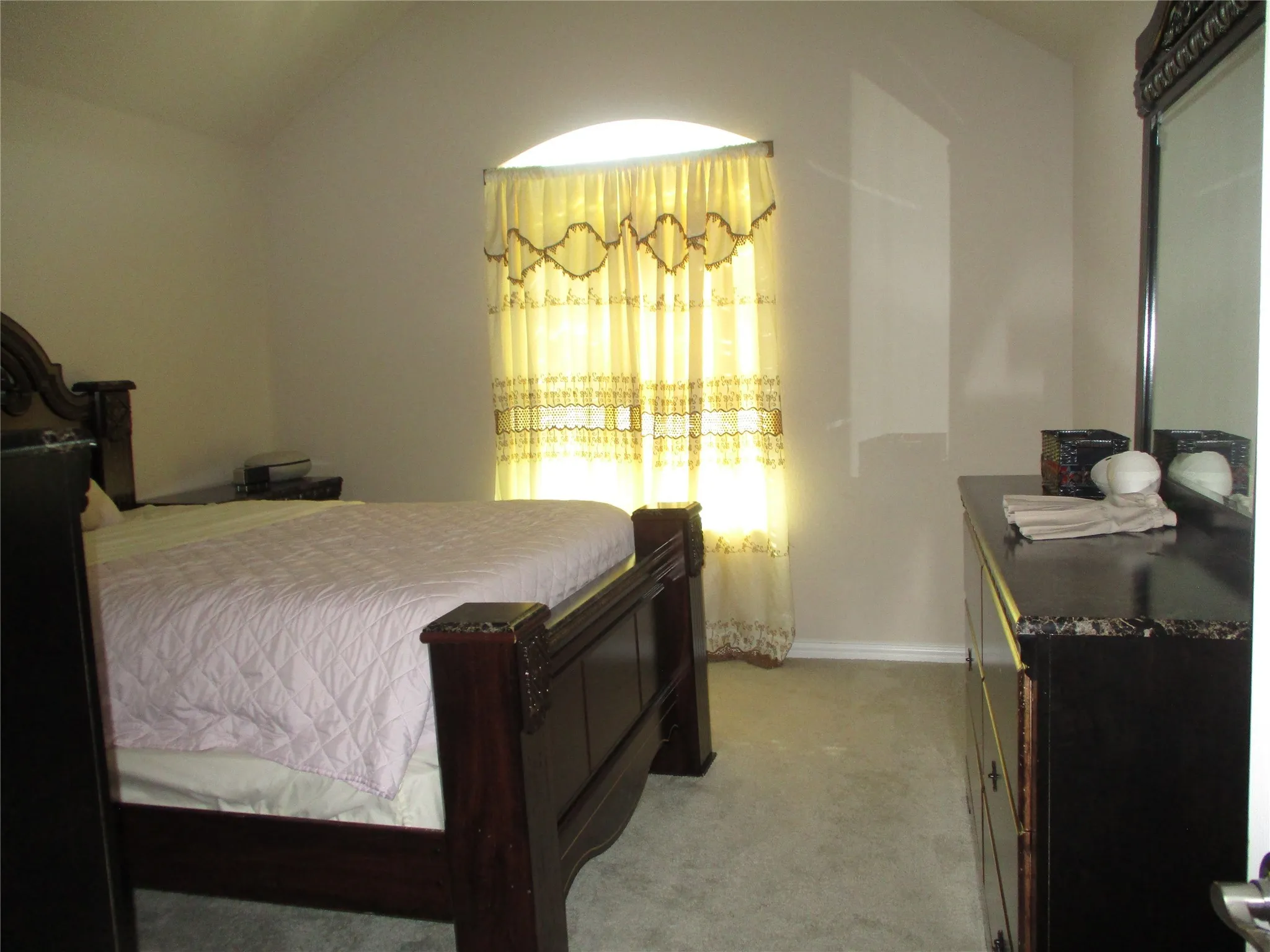 Bedroom with light carpet and lofted ceiling