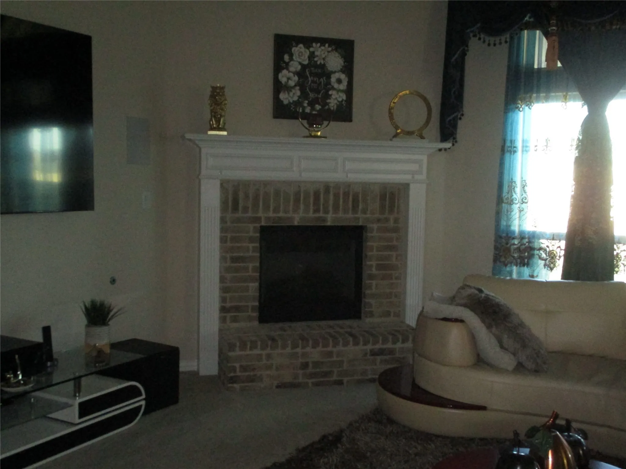 Living room with a fireplace and carpet flooring