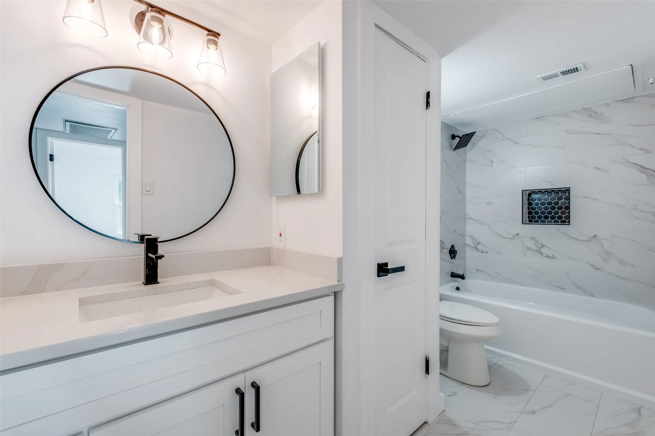 Bathroom with vanity, shower / bath combination, toilet, visible vents, and marble finish floor