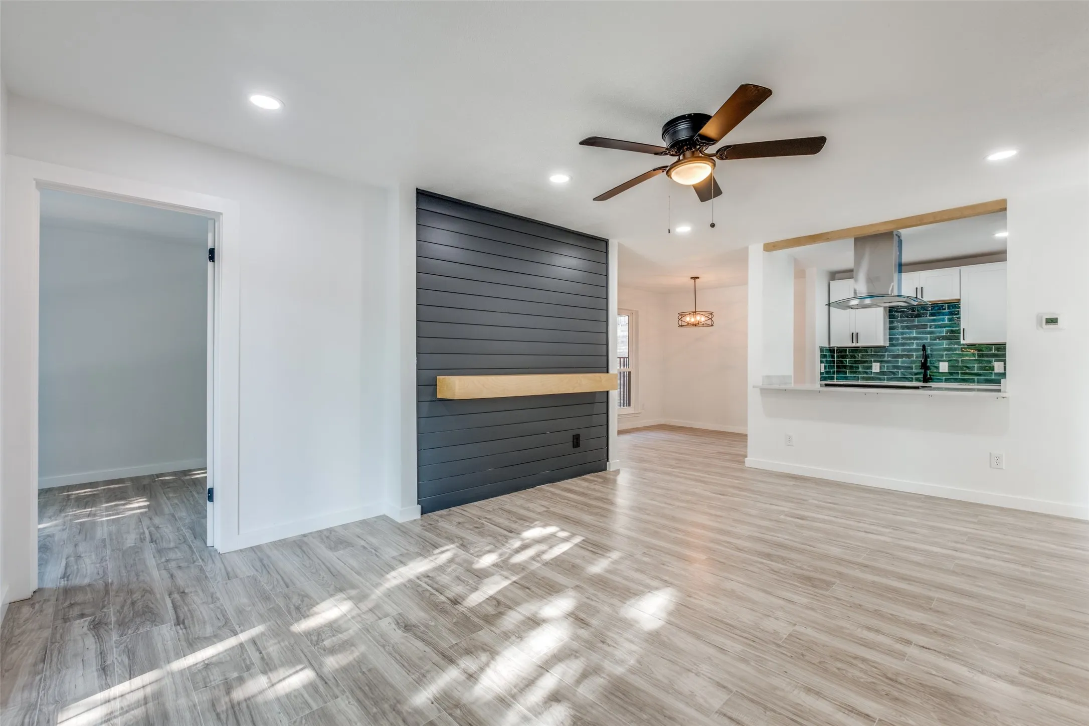 Unfurnished living room with light wood-style flooring, baseboards, a ceiling fan, and recessed lighting