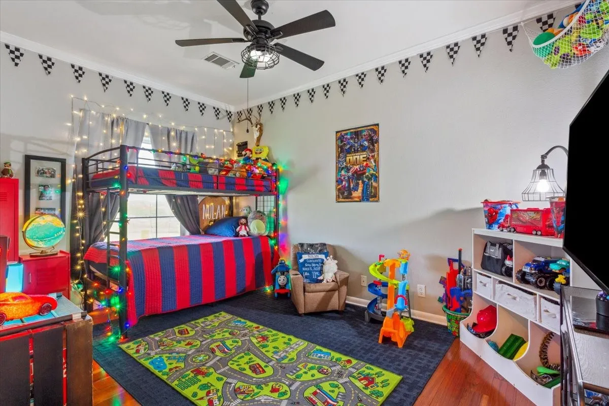 Game room with wood finished floors, visible vents, baseboards, and ceiling fan