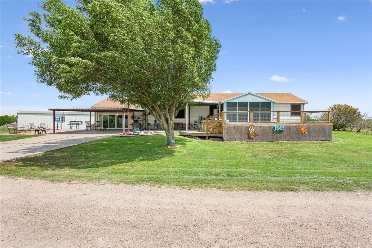 View of front of house featuring driveway, a front yard, and a carport