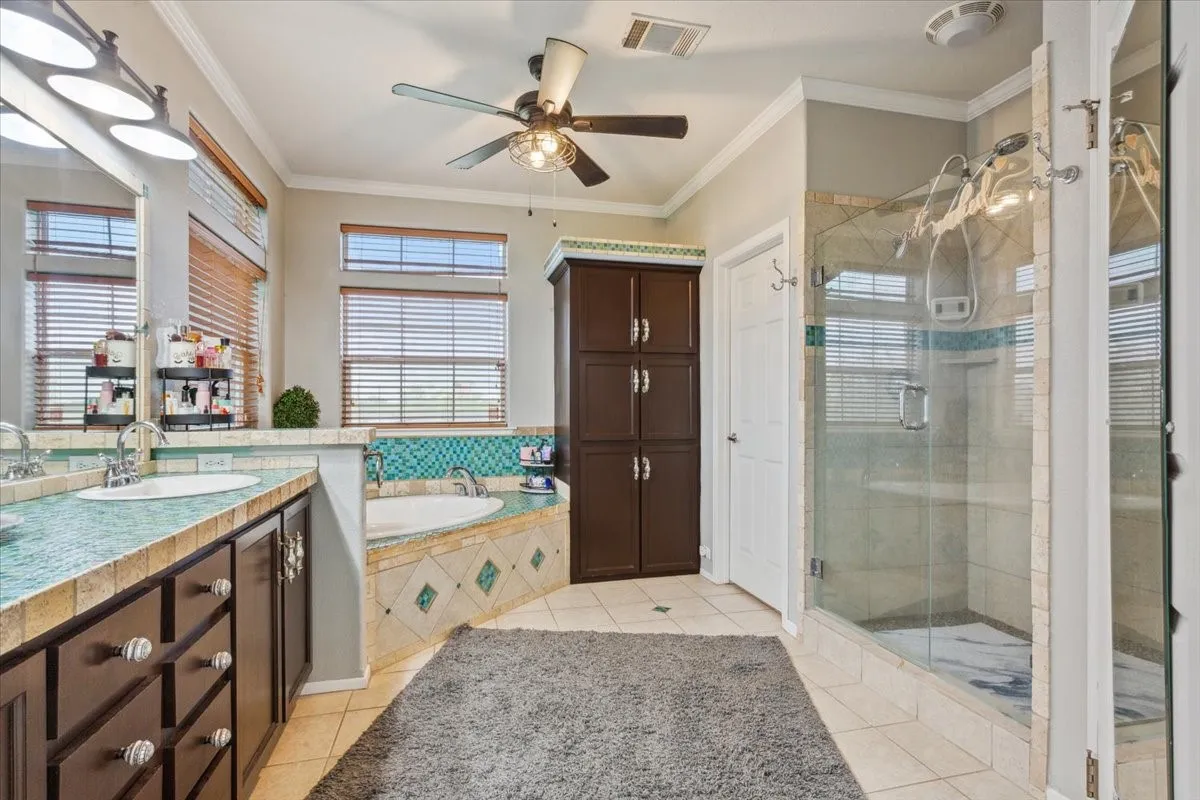 Bathroom featuring a shower stall, tile patterned flooring, visible vents, a ceiling fan, and a bath