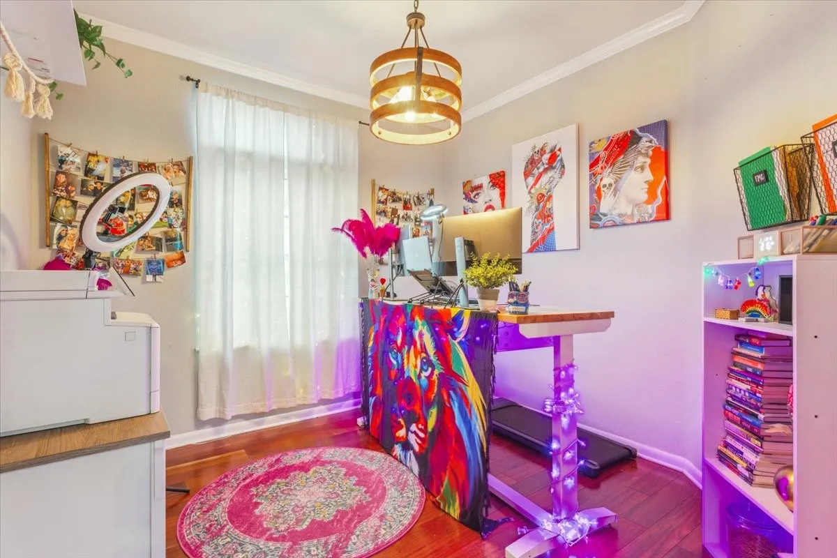 Rec room featuring baseboards, wood finished floors, an inviting chandelier, and ornamental molding