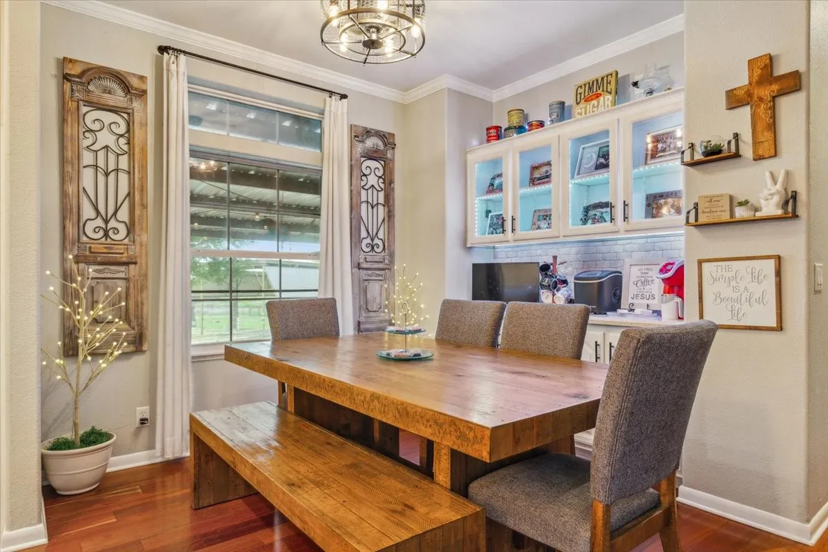 Dining area with baseboards, a chandelier, and wood finished floors