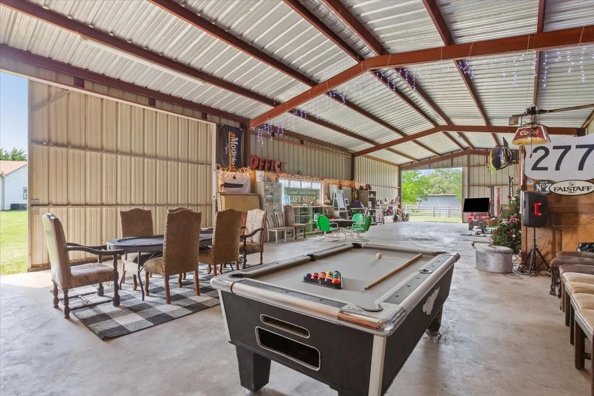 Playroom with a garage, pool table, and unfinished concrete flooring